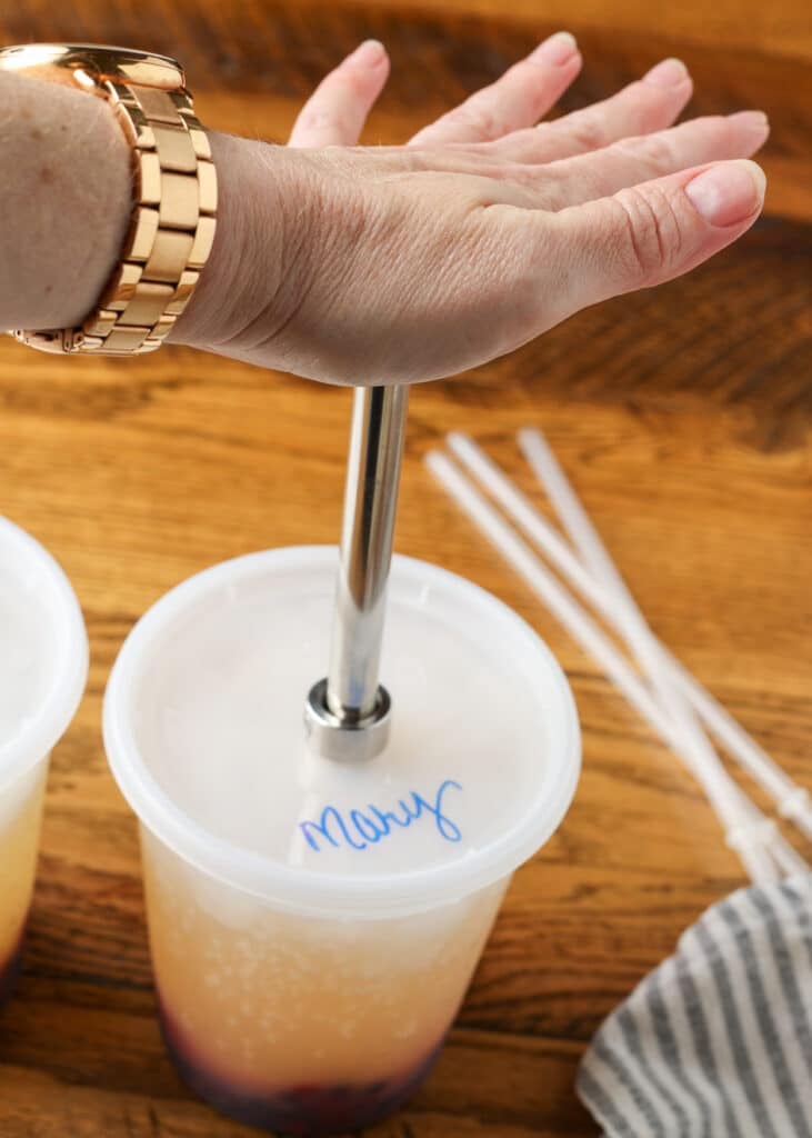 punching a hole in the lid of a deli container for a straw