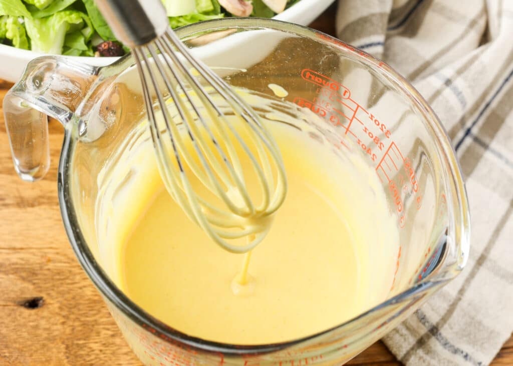 close up of honey mustard dressing on a whisk
