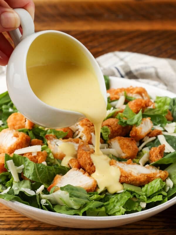 pouring dressing over salad