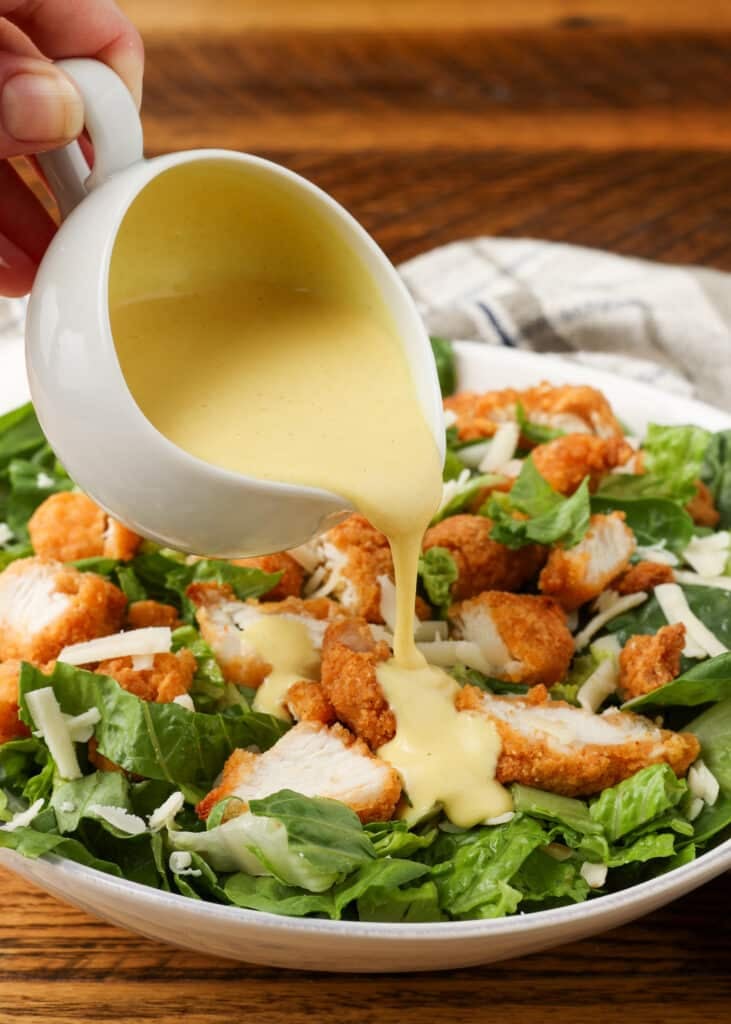 pouring dressing over salad