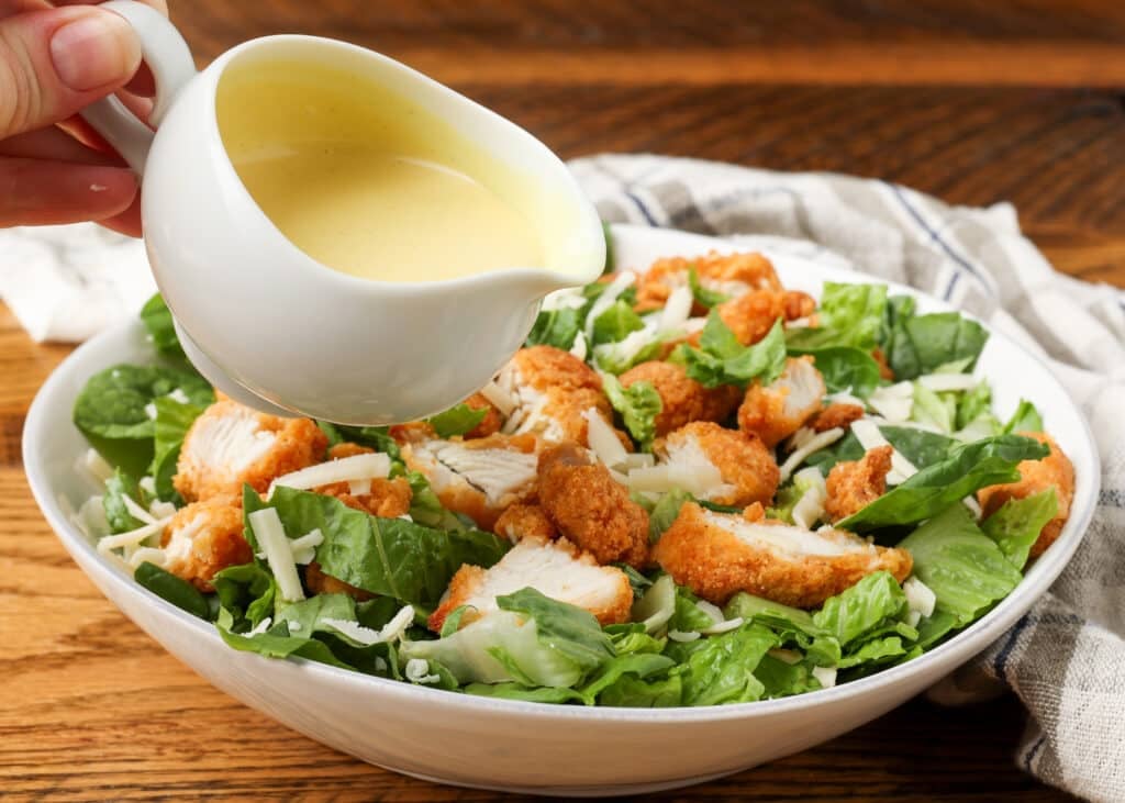 dressing held over salad about to be poured