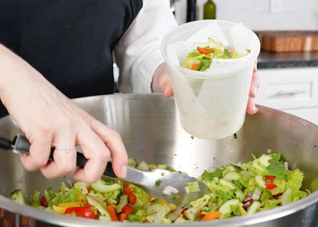 placing salad into storage containers