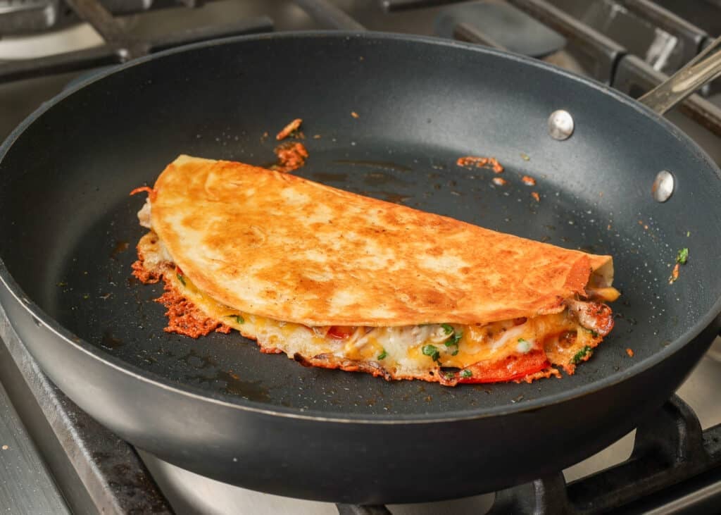 golden brown folded quesadilla in skillet