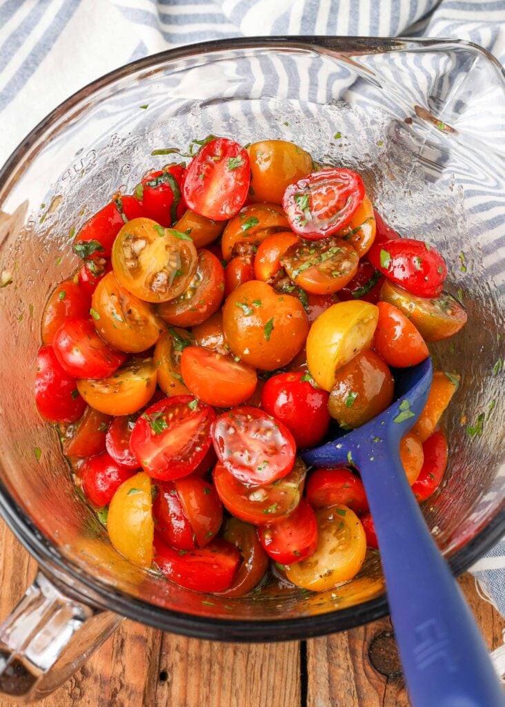 tomatoes with herbs in mixing bowl