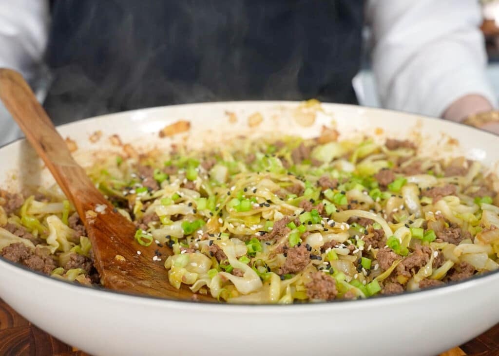 finished stir fry in white enamel skillet