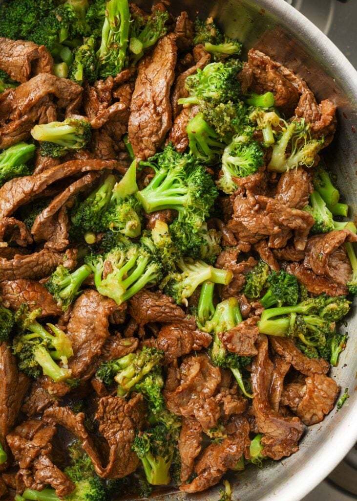 stainless skillet holding broccoli beef stir fry